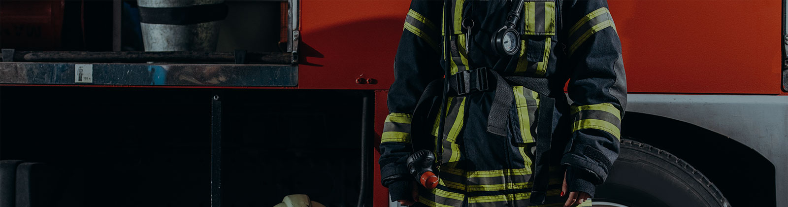 firefighter in uniform standing in front of fire truck